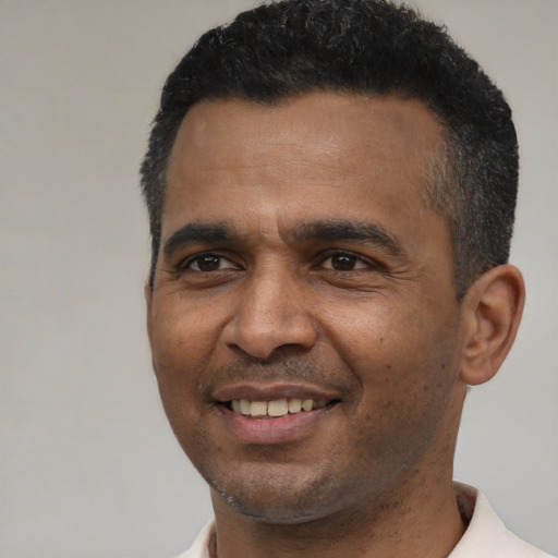 Joyful latino adult male with short  black hair and brown eyes