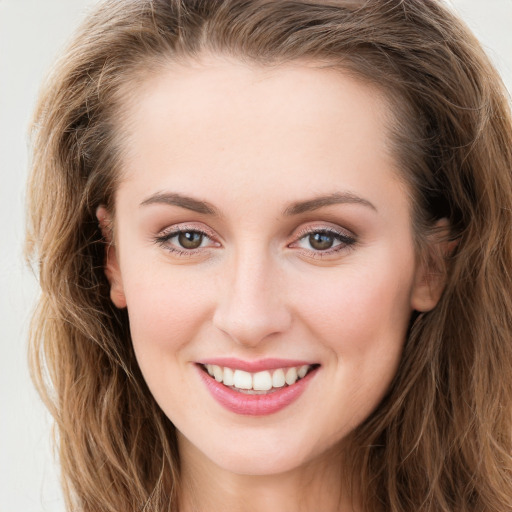 Joyful white young-adult female with long  brown hair and blue eyes