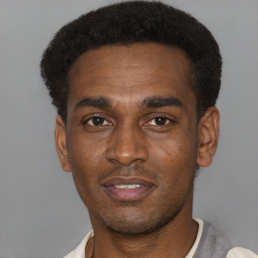 Joyful black young-adult male with short  black hair and brown eyes