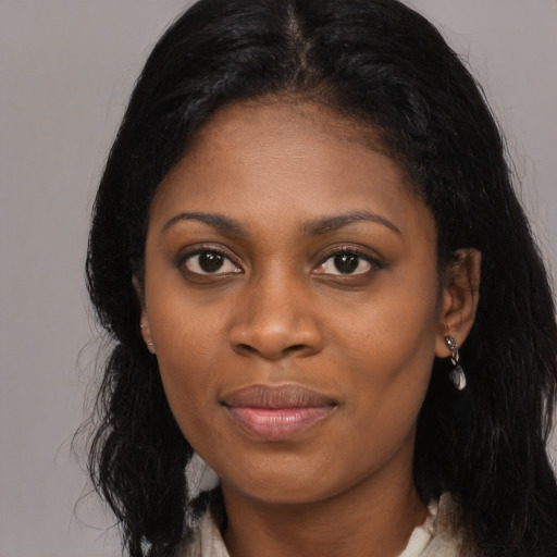 Joyful black young-adult female with long  black hair and brown eyes