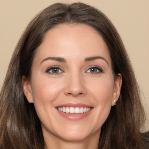 Joyful white young-adult female with long  brown hair and brown eyes