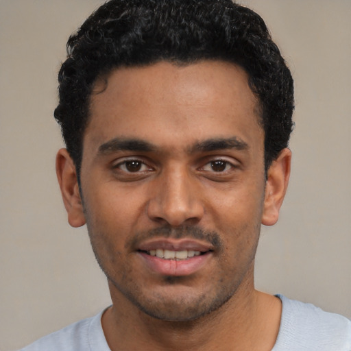 Joyful latino young-adult male with short  black hair and brown eyes