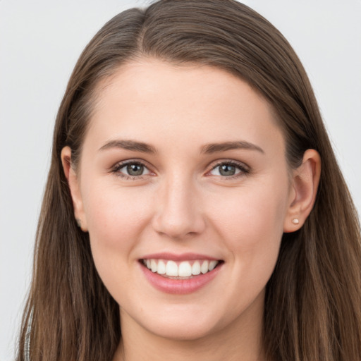 Joyful white young-adult female with long  brown hair and grey eyes