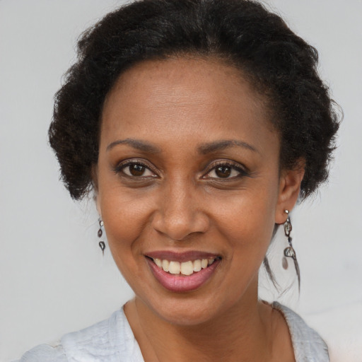 Joyful black adult female with short  brown hair and brown eyes