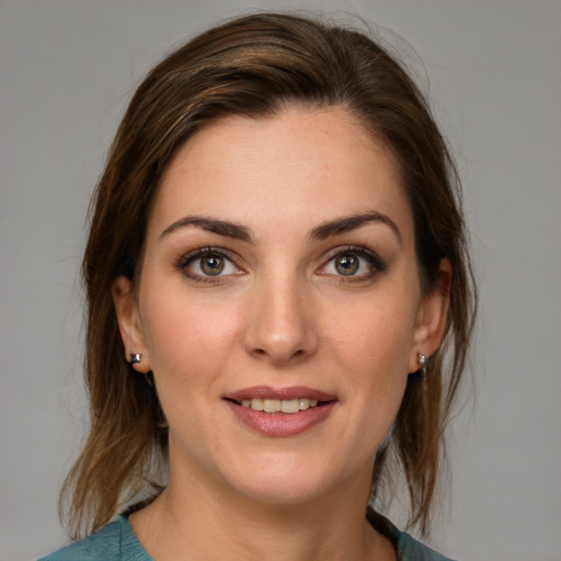 Joyful white young-adult female with medium  brown hair and grey eyes