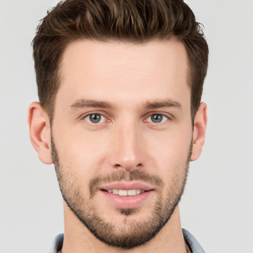 Joyful white young-adult male with short  brown hair and grey eyes