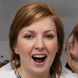 Joyful white adult female with medium  brown hair and blue eyes