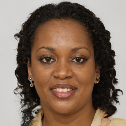 Joyful black adult female with long  brown hair and brown eyes
