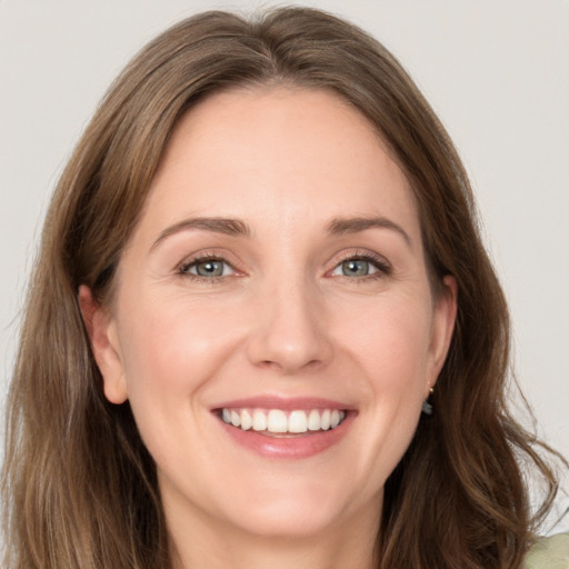 Joyful white young-adult female with long  brown hair and green eyes