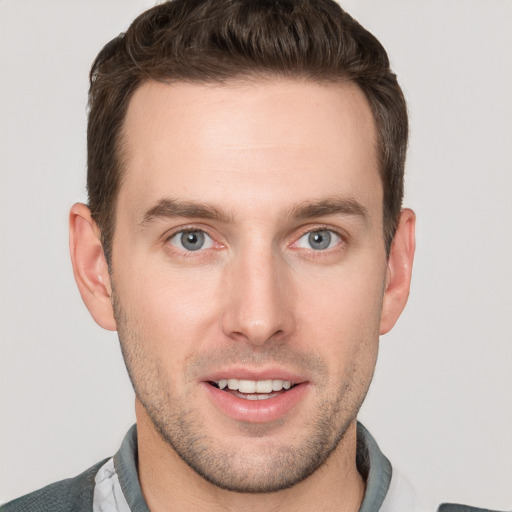 Joyful white young-adult male with short  brown hair and grey eyes