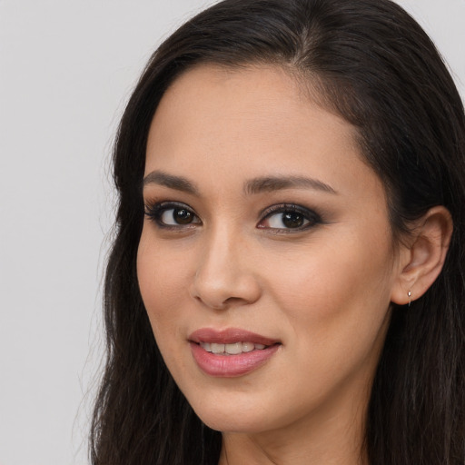 Joyful latino young-adult female with long  brown hair and brown eyes