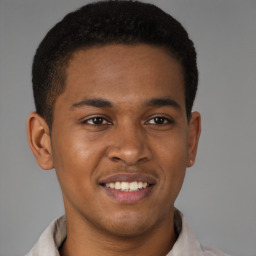 Joyful black young-adult male with short  brown hair and brown eyes