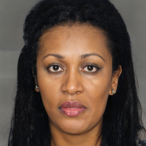 Joyful black young-adult female with long  black hair and brown eyes