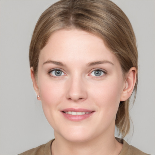 Joyful white young-adult female with medium  brown hair and grey eyes