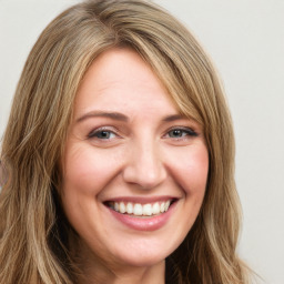 Joyful white young-adult female with long  brown hair and green eyes