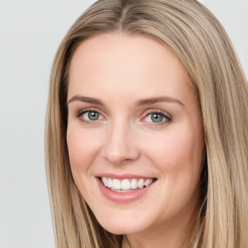 Joyful white young-adult female with long  brown hair and blue eyes