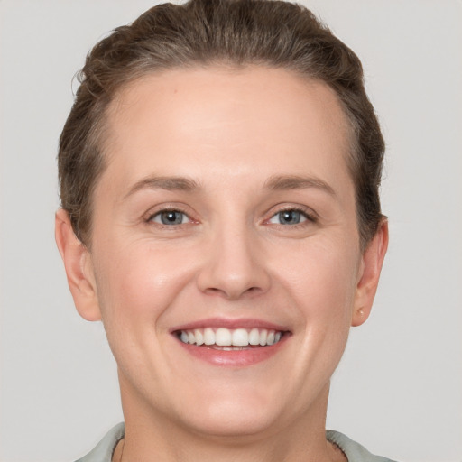 Joyful white young-adult female with short  brown hair and grey eyes