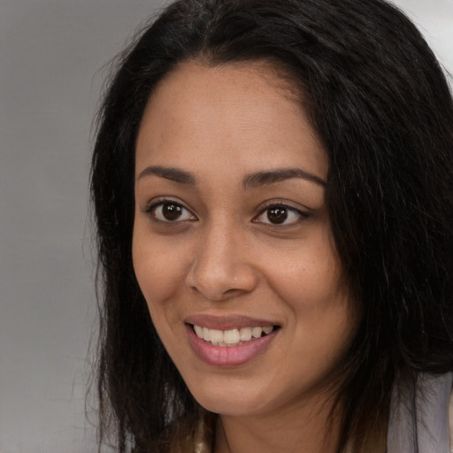 Joyful latino young-adult female with long  black hair and brown eyes