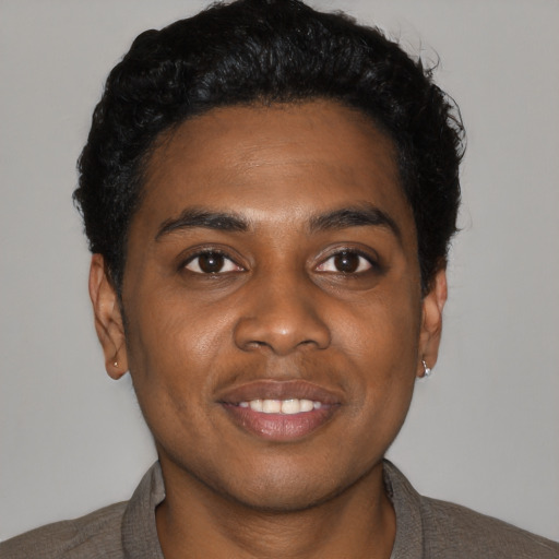 Joyful black young-adult male with short  black hair and brown eyes