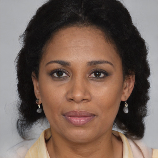 Joyful black adult female with medium  brown hair and brown eyes
