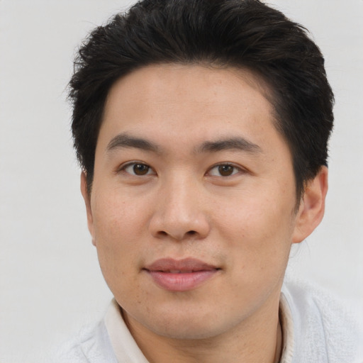 Joyful asian young-adult male with short  brown hair and brown eyes