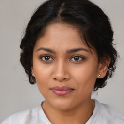 Joyful latino young-adult female with medium  brown hair and brown eyes