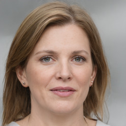 Joyful white adult female with medium  brown hair and grey eyes