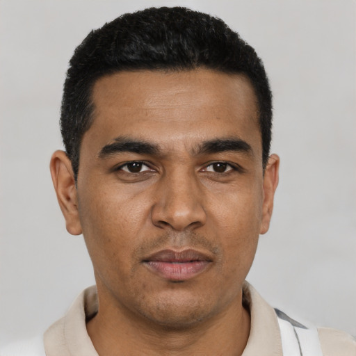 Joyful latino young-adult male with short  black hair and brown eyes