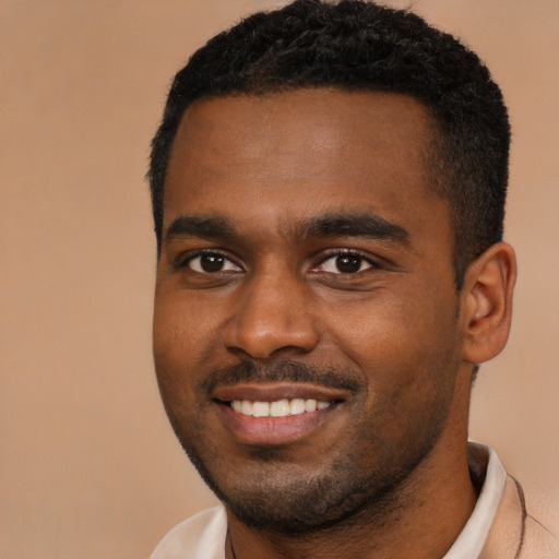 Joyful black young-adult male with short  black hair and brown eyes