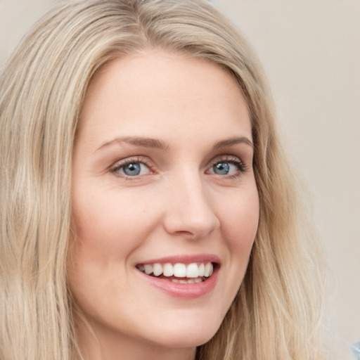 Joyful white young-adult female with long  brown hair and blue eyes