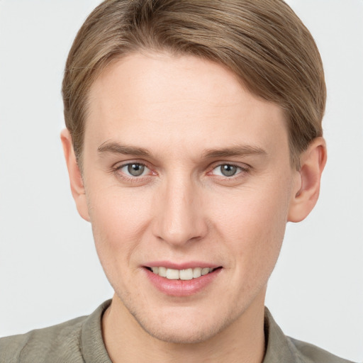 Joyful white young-adult male with short  brown hair and grey eyes