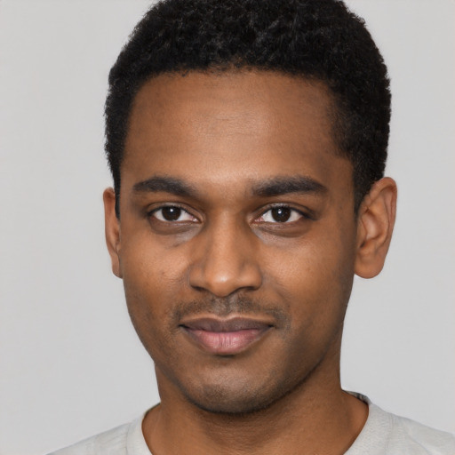 Joyful black young-adult male with short  black hair and brown eyes