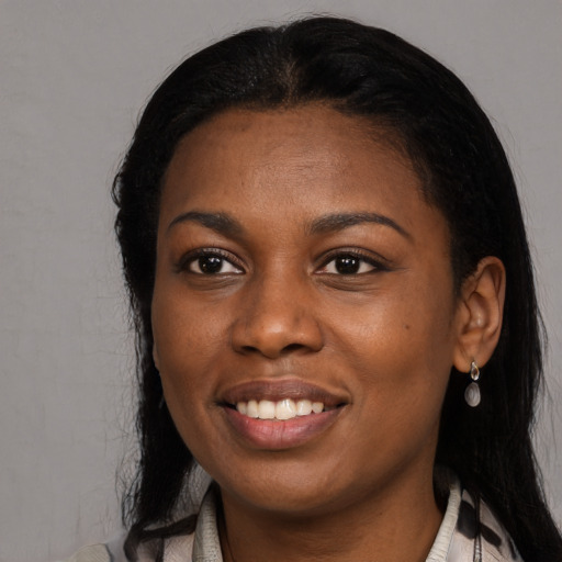 Joyful black young-adult female with long  black hair and brown eyes