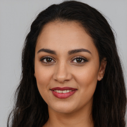 Joyful latino young-adult female with long  brown hair and brown eyes