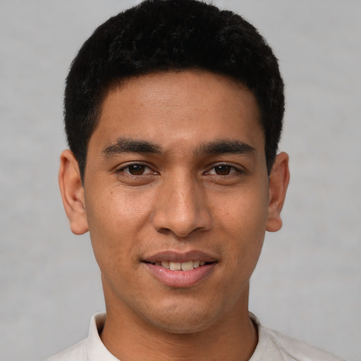 Joyful latino young-adult male with short  black hair and brown eyes