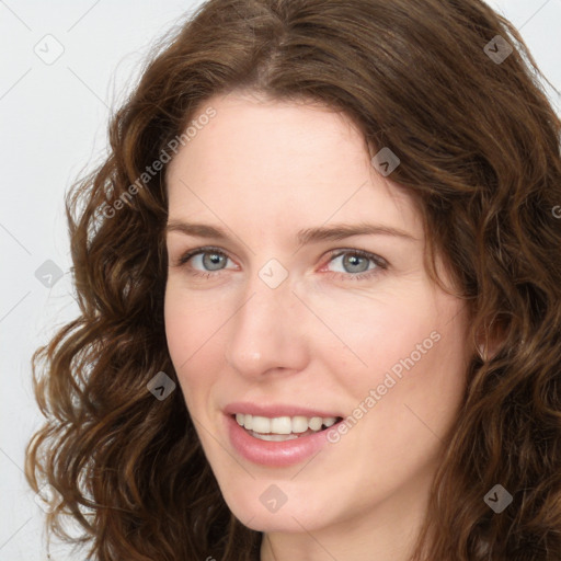 Joyful white young-adult female with long  brown hair and green eyes