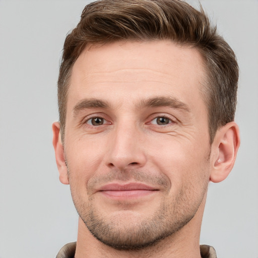 Joyful white young-adult male with short  brown hair and grey eyes