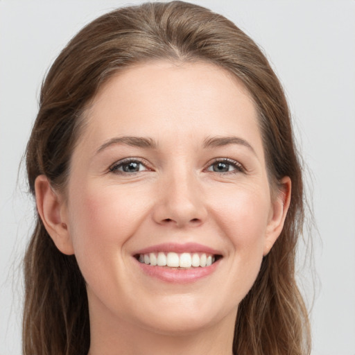 Joyful white young-adult female with long  brown hair and grey eyes