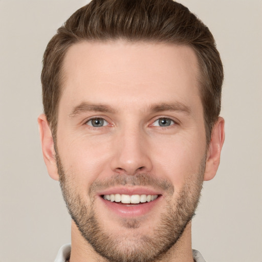 Joyful white young-adult male with short  brown hair and grey eyes