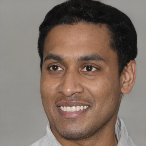 Joyful latino young-adult male with short  black hair and brown eyes