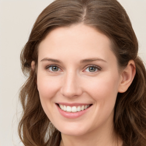 Joyful white young-adult female with long  brown hair and green eyes