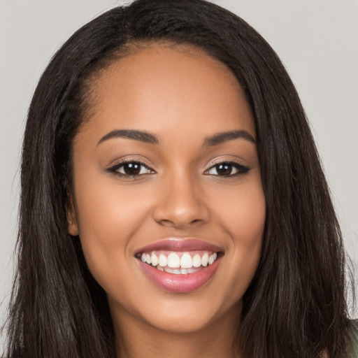 Joyful latino young-adult female with long  brown hair and brown eyes