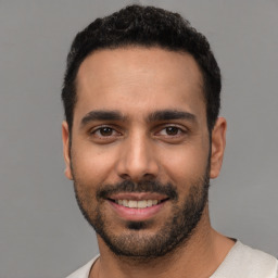 Joyful white young-adult male with short  black hair and brown eyes