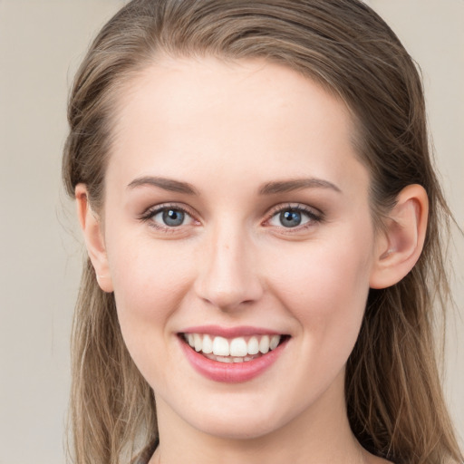 Joyful white young-adult female with long  brown hair and grey eyes