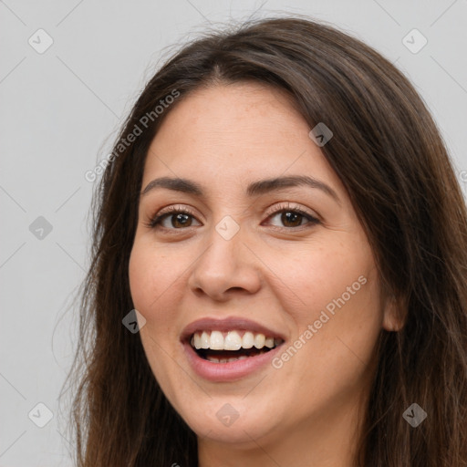 Joyful white young-adult female with long  brown hair and brown eyes