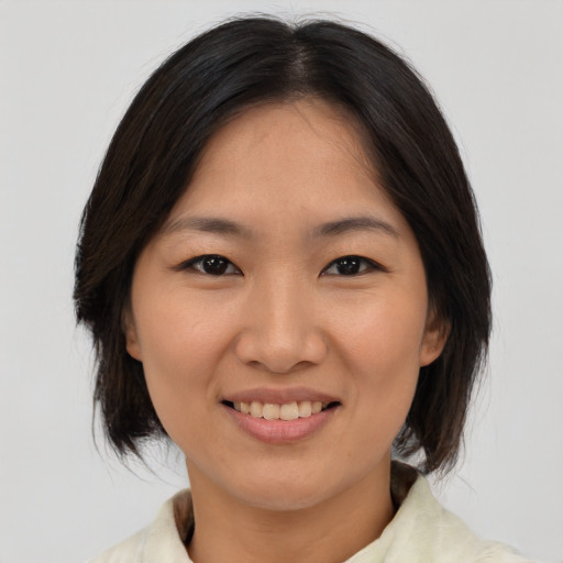 Joyful asian adult female with medium  brown hair and brown eyes