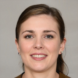 Joyful white young-adult female with medium  brown hair and blue eyes