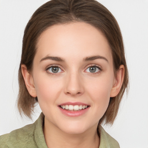 Joyful white young-adult female with medium  brown hair and green eyes