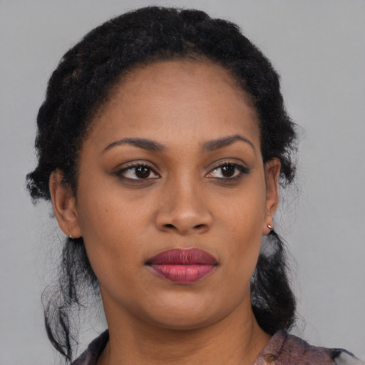 Joyful black young-adult female with medium  black hair and brown eyes