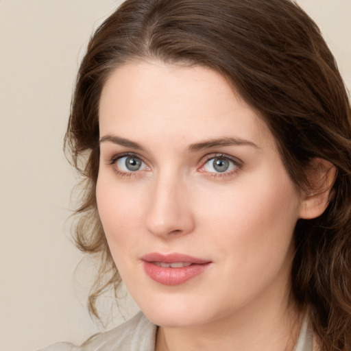 Joyful white young-adult female with medium  brown hair and green eyes